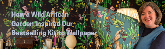 Kitito wallpaper in dark navy on background with teal wallpaper being held up in front by designer