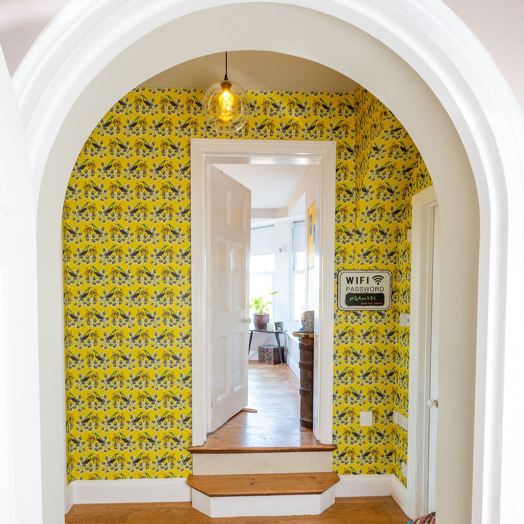 Bright yellow tropical Kirimiri wallpaper in a hallway with arch.