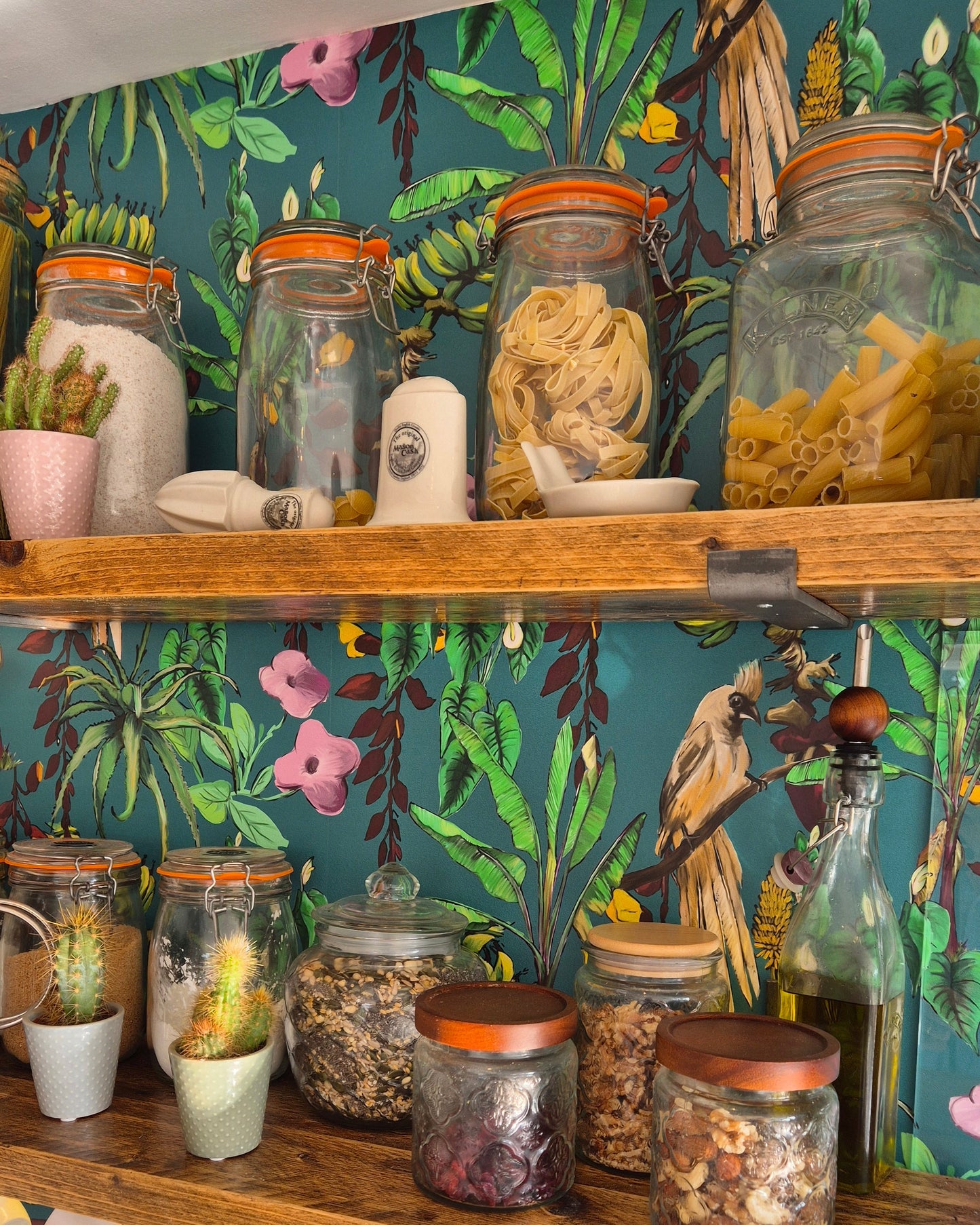 Wooden spice rack with jars on a floral-patterned Kitito wallpaper