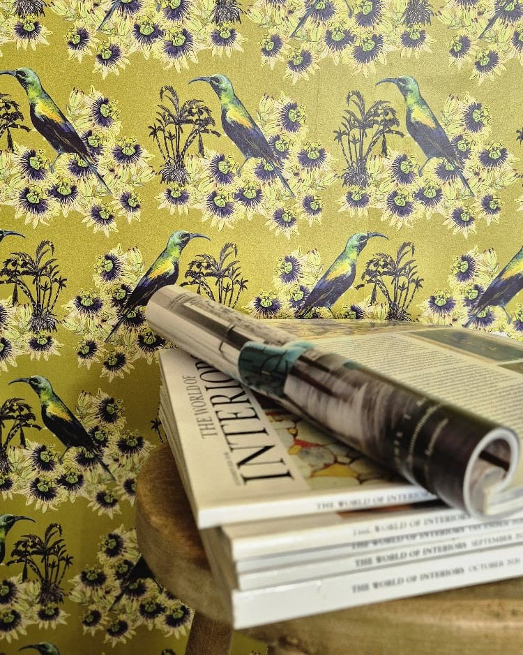 Stack of The World of Interiors Magazines on a wooden stool against a Olive Kirimiri wallpapered wall.