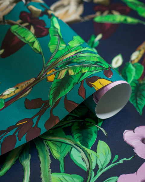 Two tropical wallpapers. blue wallpaper in background and teal tropical wallpaper roll on top.